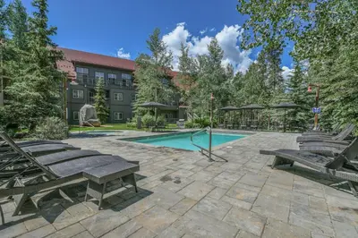 a patio with benches and a swimming pool at Expedition Station 8635 by SummitCove Lodging in Keystone