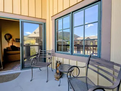 a porch with two chairs and a bench and windows at Expedition Station 8635 by SummitCove Lodging in Keystone