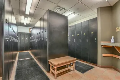 a locker room with black lockers and a wooden bench at Expedition Station 8635 by SummitCove Lodging in Keystone