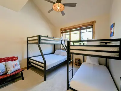 two bunk beds in a room with a ceiling fan at Settlers Creek 6529 by SummitCove Lodging in Keystone