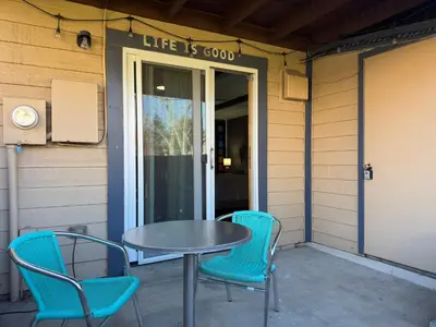 a table and chairs on a patio with a sign that reads life is good at Cozy Room with Private Entrance and Patio near Denver in Westminster