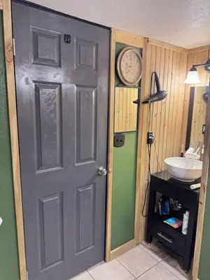 a bathroom door with a sink and a clock on the wall at Cozy Room with Private Entrance and Patio near Denver in Westminster