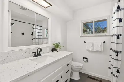 a white bathroom with a sink and a toilet at Moody Modern Getaway Walk to CSU and City Park in Fort Collins