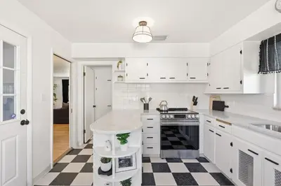 a white kitchen with a black and white checkered floor at Moody Modern Getaway Walk to CSU and City Park in Fort Collins
