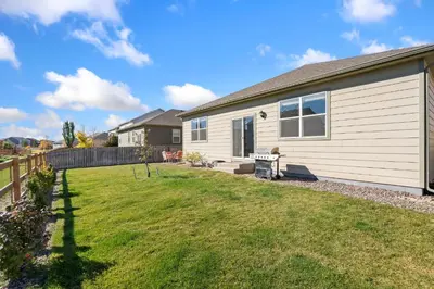 a house with a fence and a yard at Windshire Retreat with Pool, Garage and Pet-Friendly in Windsor