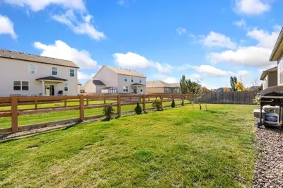 a fence in a yard next to a house at Windshire Retreat with Pool, Garage and Pet-Friendly in Windsor