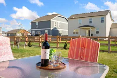 a bottle of wine sitting on a table with a glass at Windshire Retreat with Pool, Garage and Pet-Friendly in Windsor