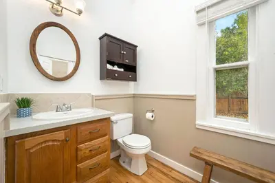 a bathroom with a toilet and a sink and a mirror at Oak Street Bungalow Walk to Old Town and CSU in Fort Collins