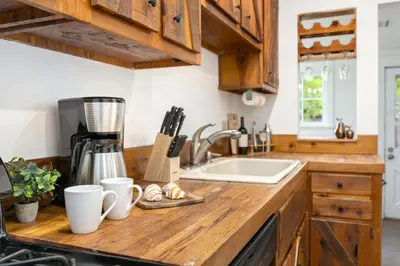 a kitchen counter with a sink and wooden cabinets at Oak Street Bungalow Walk to Old Town and CSU in Fort Collins