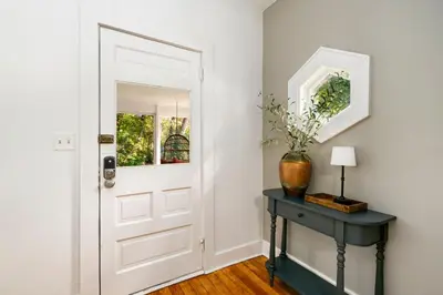 a white door in a room with a table and a vase at Oak Street Bungalow Walk to Old Town and CSU in Fort Collins