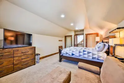 a bedroom with a bed and a tv and a couch at Barnwood Beauty at Grand Elk- Pet Friendly- Hot Tub Private Golf Ski Games in Granby