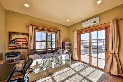 a bedroom with a bed and a desk and a window at Barnwood Beauty at Grand Elk- Pet Friendly- Hot Tub Private Golf Ski Games in Granby