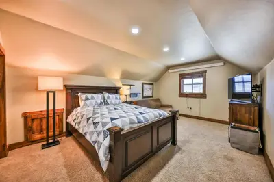 a bedroom with a large bed and a television at Barnwood Beauty at Grand Elk- Pet Friendly- Hot Tub Private Golf Ski Games in Granby