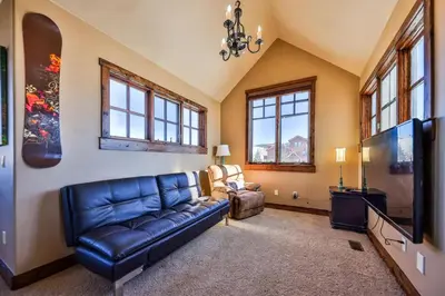 a living room with a blue couch and a tv at Barnwood Beauty at Grand Elk- Pet Friendly- Hot Tub Private Golf Ski Games in Granby
