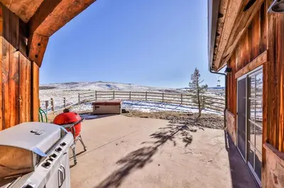 a view from the porch of a house with a stove at Barnwood Beauty at Grand Elk- Pet Friendly- Hot Tub Private Golf Ski Games in Granby