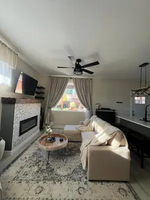 a living room with a couch and a ceiling fan at Su Casa Studio in Denver