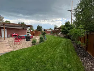 a yard with green grass and a fence at Su Casa Studio in Denver