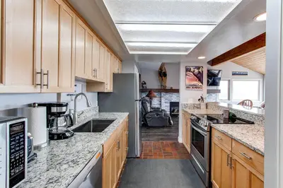a kitchen with marble counter tops and wooden cabinets at 10-Person HotTub, ViewHouse, Steps to Trail, Close to Ski Resorts, FirePit in Silverthorne