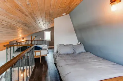 a small bedroom with a bed and a staircase at 10-Person HotTub, ViewHouse, Steps to Trail, Close to Ski Resorts, FirePit in Silverthorne