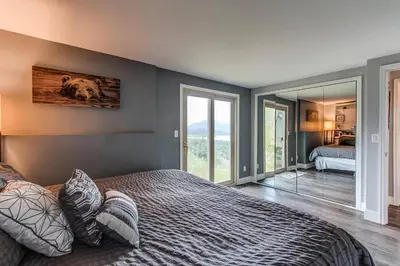 a bedroom with a large bed and a mirror at 10-Person HotTub, ViewHouse, Steps to Trail, Close to Ski Resorts, FirePit in Silverthorne
