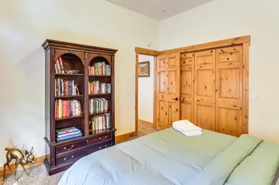 a bedroom with a bed and a book shelf with books at Mtn-View Cabin with Private Hot Tub in Georgetown! in Georgetown