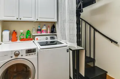 a laundry room with a washer and a staircase at Mtn-View Cabin with Private Hot Tub in Georgetown! in Georgetown