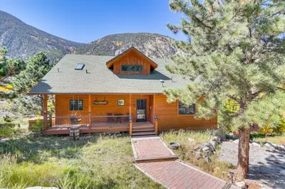 a log cabin with a porch and a mountain at Mtn-View Cabin with Private Hot Tub in Georgetown! in Georgetown