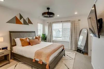 a bedroom with a bed and a television in it at Great for Families! Newly Built Home in Aurora in Aurora