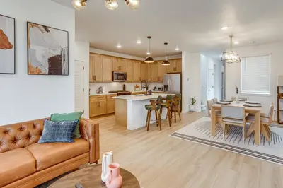 a living room and kitchen with a couch and a table at Great for Families! Newly Built Home in Aurora in Aurora