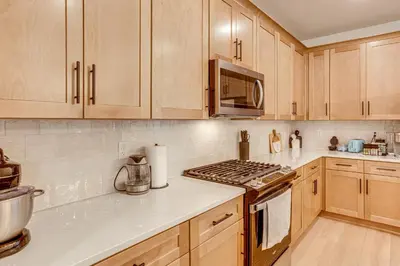 a kitchen with wooden cabinets and a stove top oven at Great for Families! Newly Built Home in Aurora in Aurora
