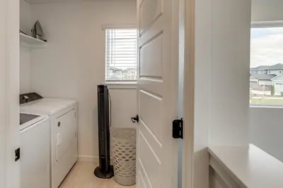 a laundry room with a washer and dryer and a door at Great for Families! Newly Built Home in Aurora in Aurora