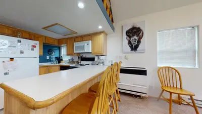 a kitchen with a white counter top and wooden cabinets at #160 Tiger Run in Breckenridge