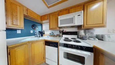 a kitchen with wooden cabinets and a white stove top oven at #160 Tiger Run in Breckenridge