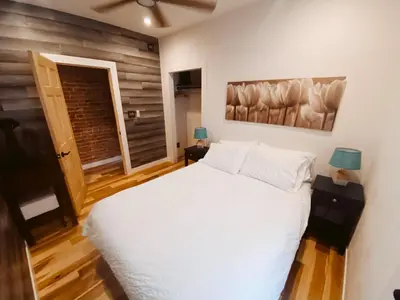 a bedroom with a white bed and a wooden floor at Blue Ox Charming 2 Bedroom Triplex - S Broadway in Denver