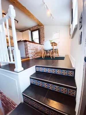 a room with stairs and a table with a chair at Blue Ox Charming 2 Bedroom Triplex - S Broadway in Denver