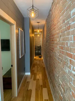 a hallway with a brick wall and a ceiling at Blue Ox Charming 2 Bedroom Triplex - S Broadway in Denver