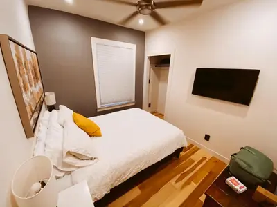 a bedroom with a bed and a flat screen tv at Blue Ox Charming 2 Bedroom Triplex - S Broadway in Denver