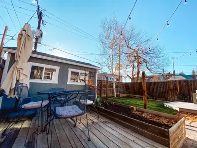 a patio with a table and chairs on a deck at Blue Ox Charming 2 Bedroom Triplex - S Broadway in Denver