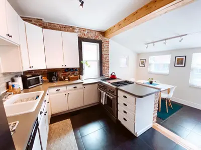 a kitchen with white cabinets and a counter top at Blue Ox Charming 2 Bedroom Triplex - S Broadway in Denver