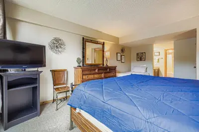 a bedroom with a blue bed and a television at 1806 Decatur condo in Keystone