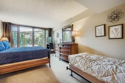 a bedroom with a bed and a television and a window at 1806 Decatur condo in Keystone