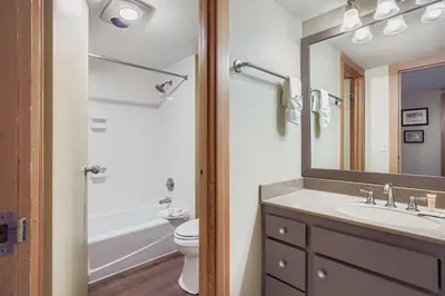 a bathroom with a sink and a toilet and a mirror at 1806 Decatur condo in Keystone