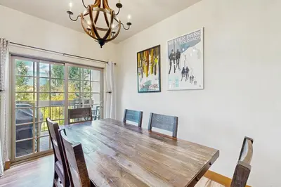 a dining room with a wooden table and chairs at Red Quill Basecamp in Winter Park