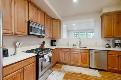 a kitchen with wooden cabinets and a stove top oven at Red Quill Basecamp in Winter Park