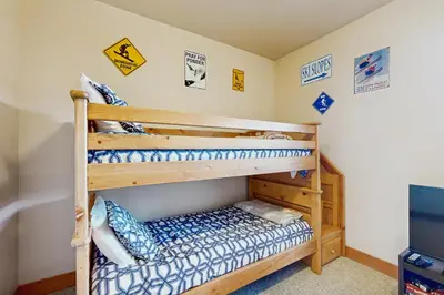 two bunk beds in a room with signs on the wall at Red Quill Basecamp in Winter Park