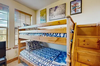 a bedroom with bunk beds and a tv at Red Quill Basecamp in Winter Park