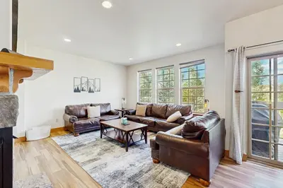 a living room with leather couches and a table at Red Quill Basecamp in Winter Park
