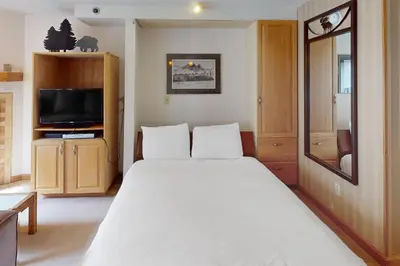 a bedroom with a large white bed and a tv at Iron Horse Resort 5064 in Winter Park