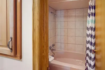 a bathroom with a tub and a shower curtain at Iron Horse Resort 5064 in Winter Park