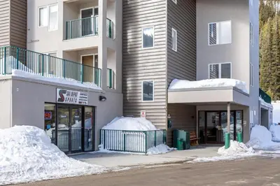 a building with snow piled up outside of it at Iron Horse Resort 5064 in Winter Park